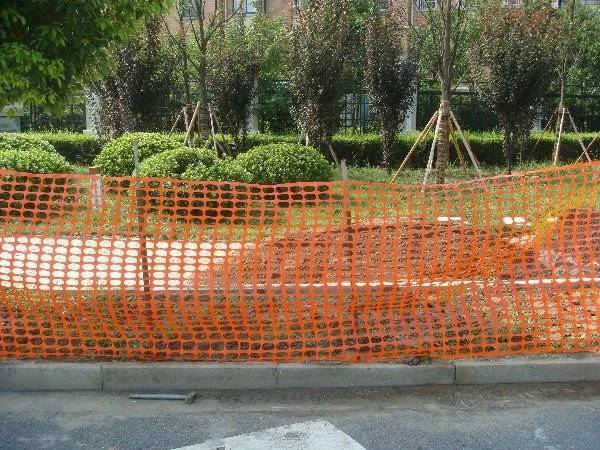 A roll of orange plastic netting used for safety barrier in public park