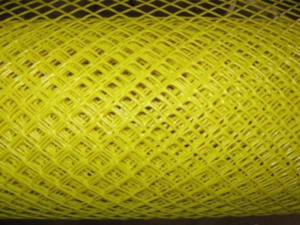 A roll of extruded square plastic mesh tree guards in yellow color tied with green plastic strips.
